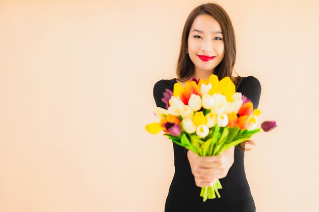 Retrato hermosa joven asiática con flores de colores