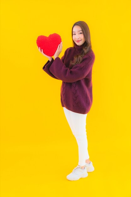 Retrato hermosa joven asiática con forma de almohada de corazón