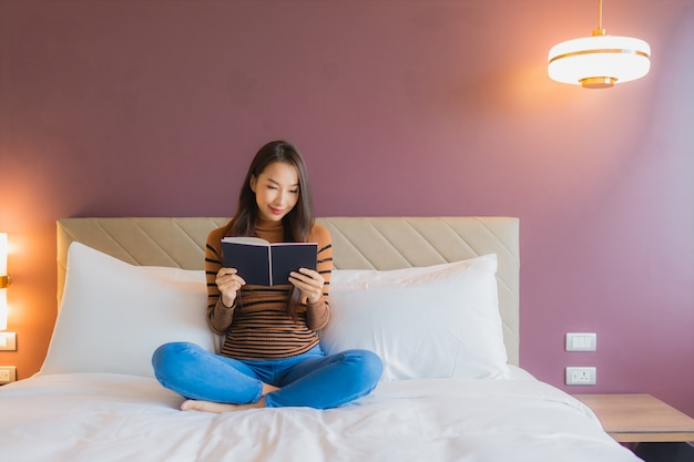 Foto gratuita retrato hermosa joven asiática leer libro en la cama