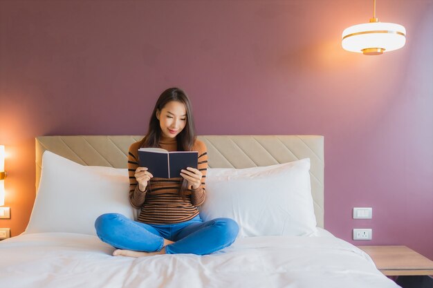 Retrato hermosa joven asiática leer libro en la cama