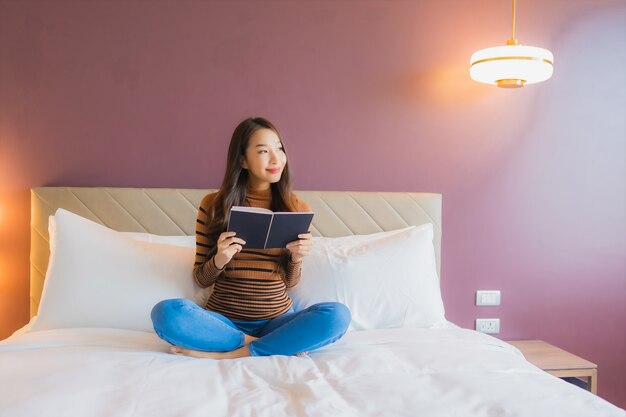 Retrato hermosa joven asiática leer libro en la cama