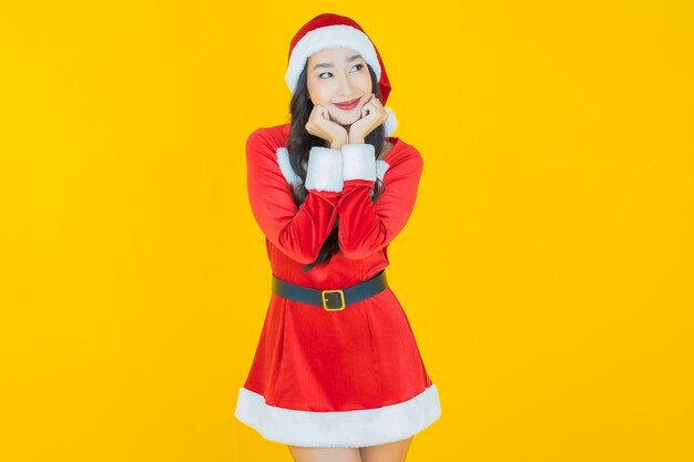 Retrato hermosa joven asiática llevar traje de navidad con acción en amarillo