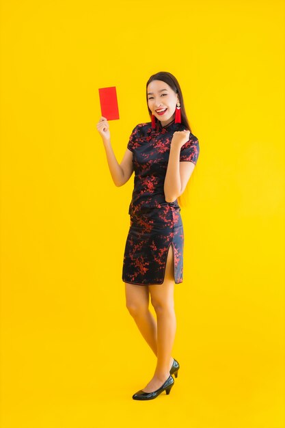 Retrato hermosa joven asiática llevar vestido chino con Ang Pao o carta roja con dinero en efectivo