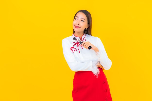 Retrato hermosa joven asiática con maquillaje cosmético de pincel en amarillo