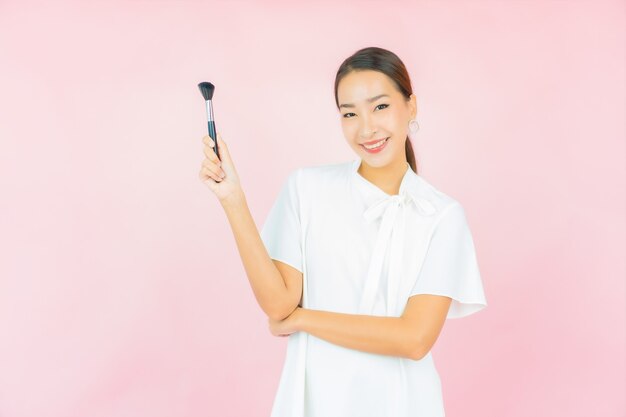 Retrato hermosa joven asiática con maquillaje cosmético de pincel
