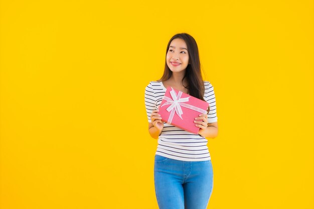 Retrato hermosa joven asiática mostrar caja de regalo roja