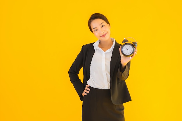 Retrato hermosa joven asiática mostrar reloj o alarma