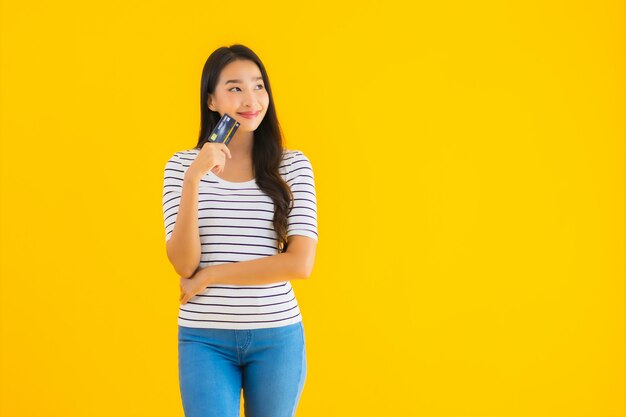 Retrato hermosa joven asiática mostrar tarjeta de crédito