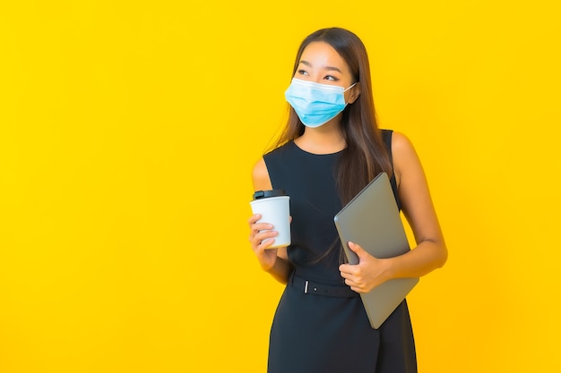 Retrato hermosa joven asiática mujer de negocios usar máscara para proteger covid19 con computadora portátil