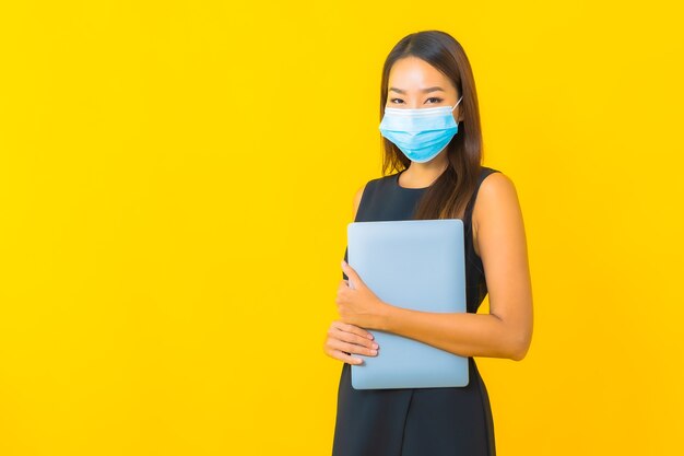 Retrato hermosa joven asiática mujer de negocios usar máscara para proteger covid19 con computadora portátil