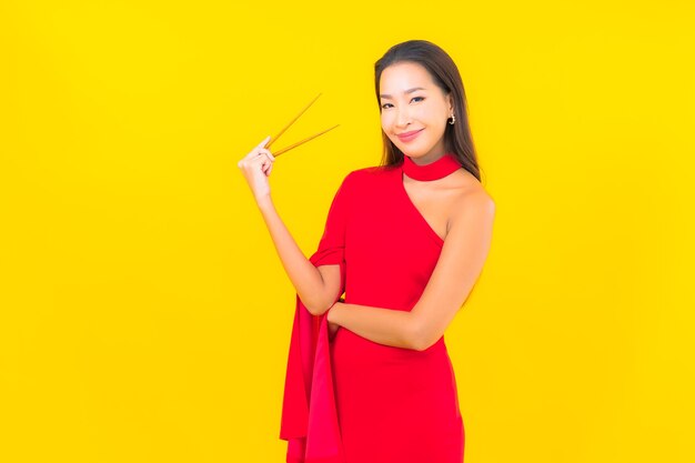 Retrato hermosa joven asiática con palillos listos para comer
