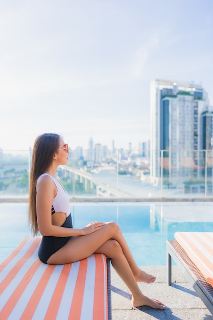 Retrato hermosa joven asiática relaja ocio alrededor de la piscina