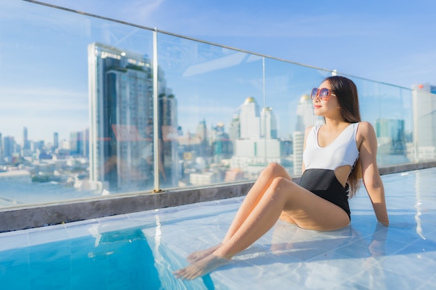 Retrato hermosa joven asiática relaja ocio alrededor de la piscina