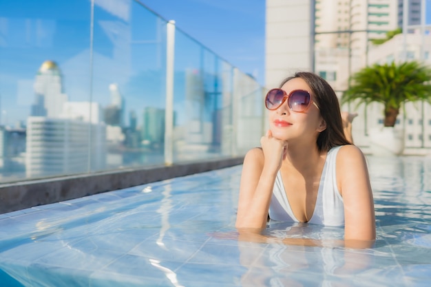 Retrato hermosa joven asiática relaja ocio alrededor de la piscina