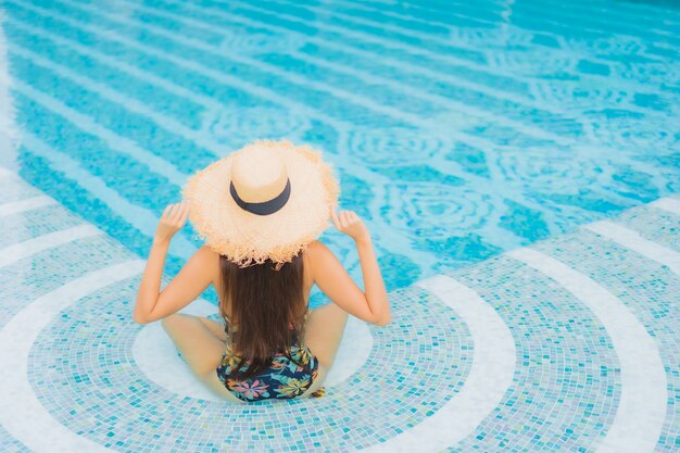 Retrato de hermosa joven asiática se relaja en la piscina en el hotel resort