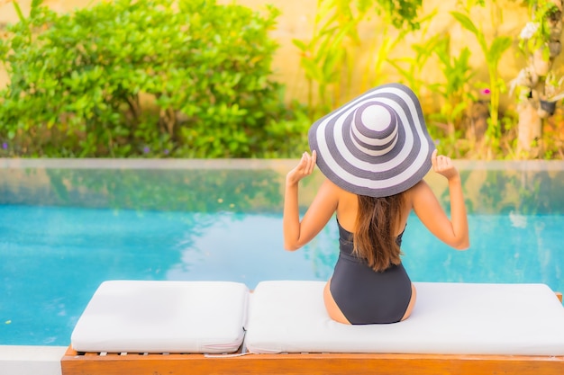 Retrato de hermosa joven asiática se relaja en la piscina