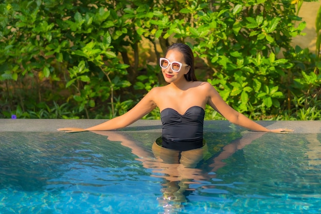 Retrato de hermosa joven asiática se relaja en la piscina