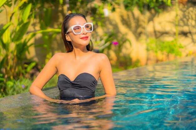 Retrato de hermosa joven asiática se relaja en la piscina