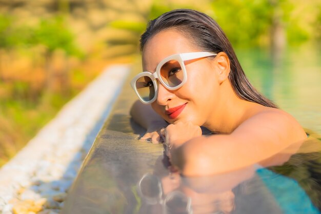 Foto gratuita retrato de hermosa joven asiática se relaja en la piscina