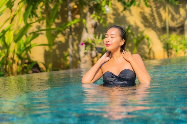 Retrato de hermosa joven asiática se relaja en la piscina