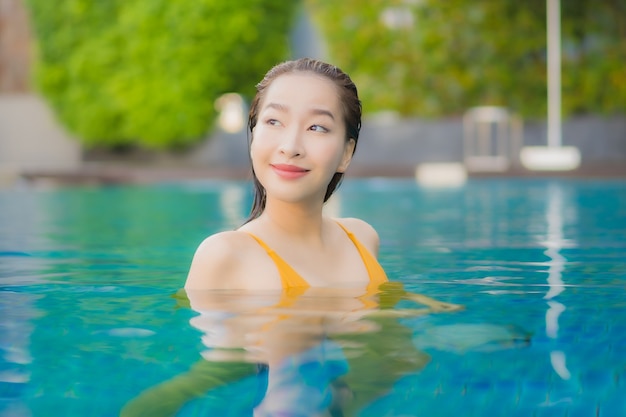 Retrato hermosa joven asiática relajante al aire libre en la piscina en viaje de vacaciones