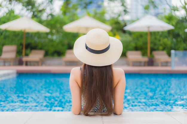 Retrato hermosa joven asiática relajante al aire libre en la piscina en viaje de vacaciones