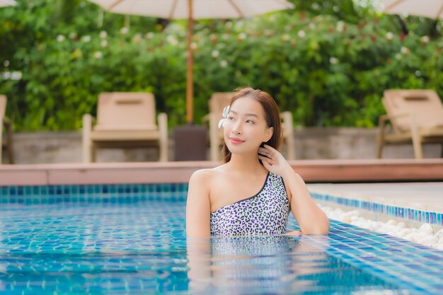 Retrato hermosa joven asiática relajante al aire libre en la piscina en viaje de vacaciones