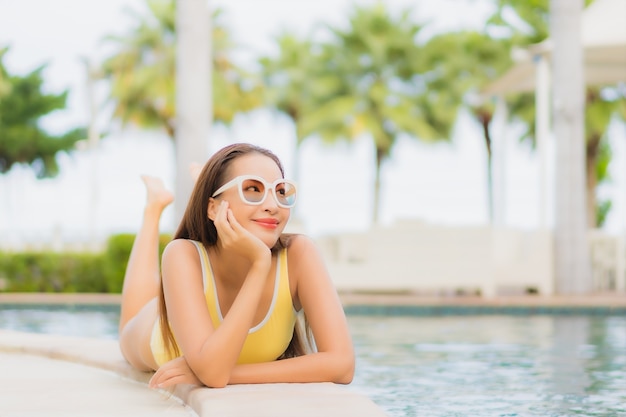 Foto gratuita retrato hermosa joven asiática relajante al aire libre en la piscina en viaje de vacaciones