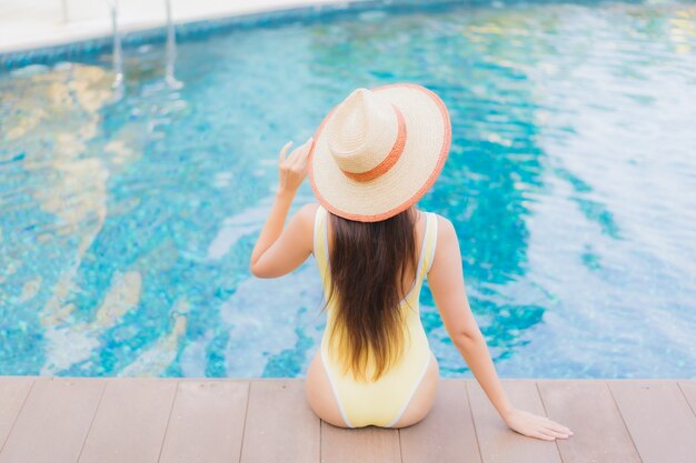 Retrato hermosa joven asiática relajante al aire libre en la piscina en viaje de vacaciones