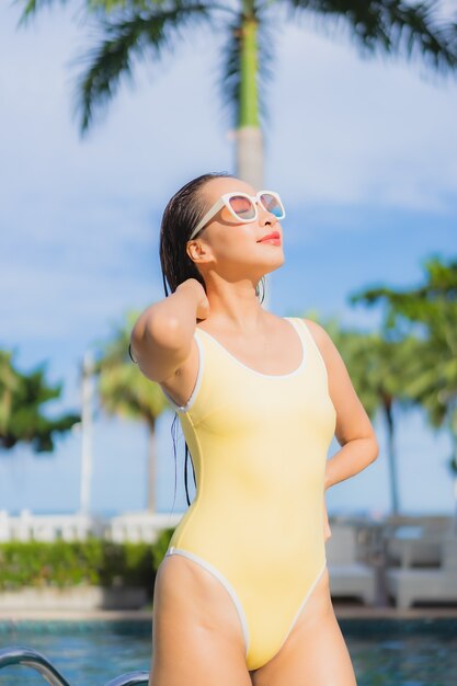 Retrato hermosa joven asiática relajante al aire libre en la piscina en viaje de vacaciones