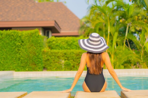 Retrato hermosa joven asiática relajante alrededor de la piscina en el hotel resort de vacaciones