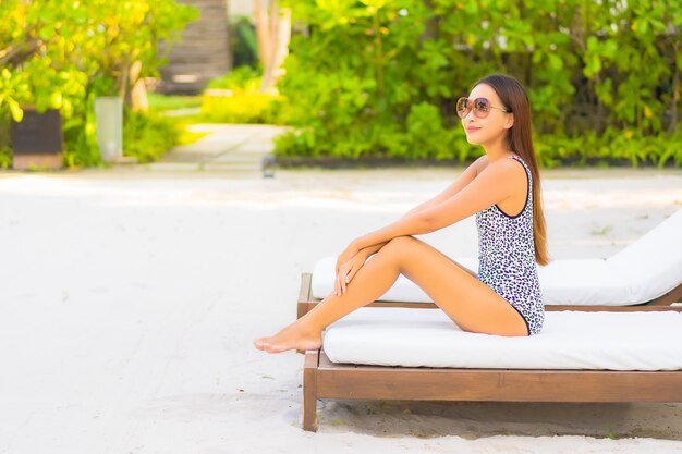 Retrato hermosa joven asiática relajante alrededor de la piscina en el hotel resort de vacaciones