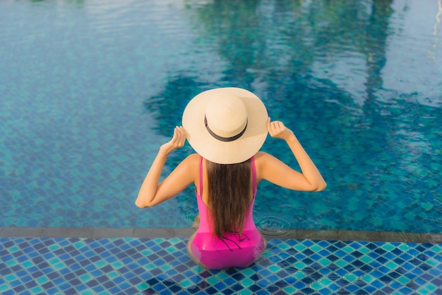 Retrato hermosa joven asiática relajarse disfrutar alrededor de la piscina al aire libre en vacaciones de vacaciones