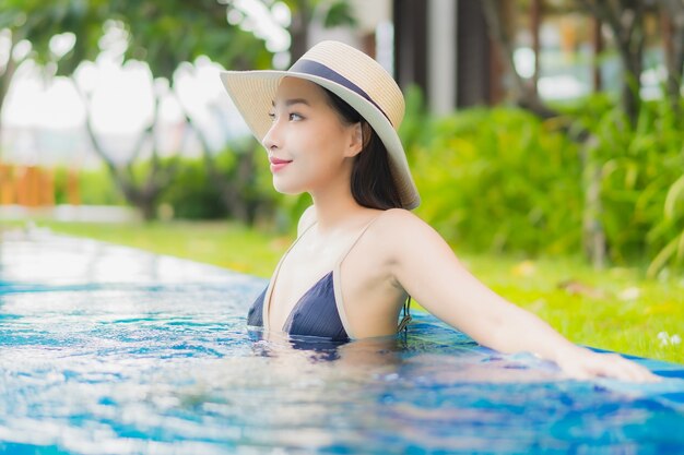 Retrato hermosa joven asiática relajarse disfrutar de una sonrisa alrededor de la piscina al aire libre en el hotel resort en vacaciones de ocio