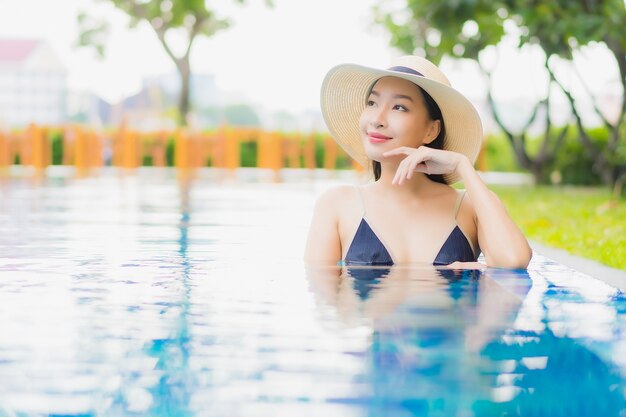 Retrato hermosa joven asiática relajarse disfrutar de una sonrisa alrededor de la piscina al aire libre en el hotel resort en vacaciones de ocio