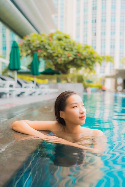 Retrato hermosa joven asiática relajarse feliz sonrisa ocio alrededor de la piscina al aire libre