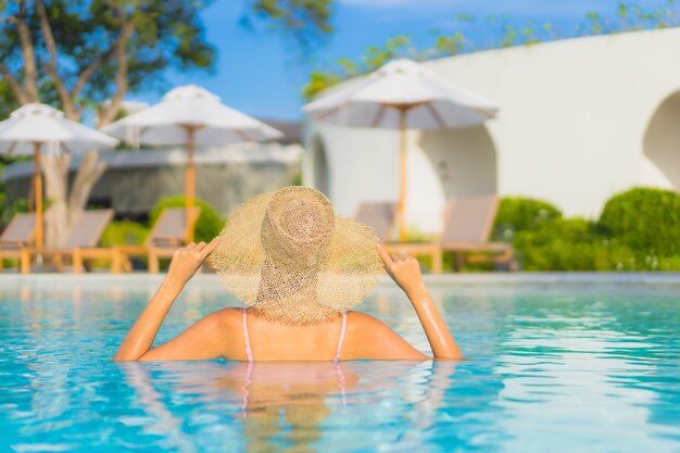 Retrato hermosa joven asiática relajarse ocio alrededor de la piscina al aire libre con mar