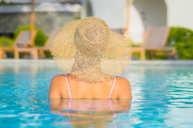 Retrato hermosa joven asiática relajarse ocio alrededor de la piscina al aire libre con mar