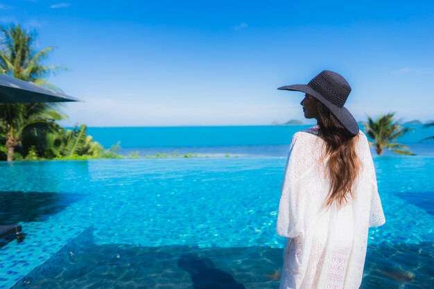 Retrato hermosa joven asiática relajarse en la piscina al aire libre de lujo en el hotel resort casi playa mar océano