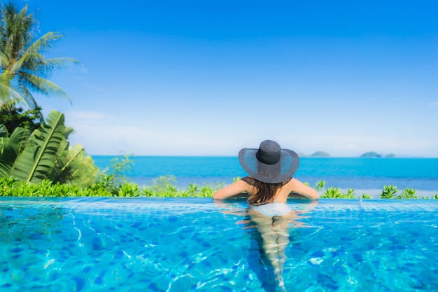 Retrato hermosa joven asiática relajarse en la piscina al aire libre de lujo en el hotel resort casi playa mar océano