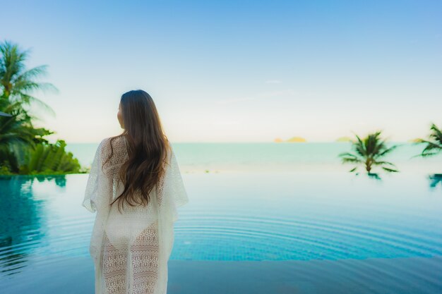 Retrato hermosa joven asiática relajarse en la piscina al aire libre de lujo en el hotel resort casi playa mar océano