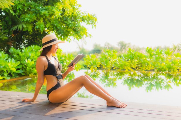 Retrato hermosa joven asiática relajarse en la piscina en el hotel resort para vacaciones de ocio