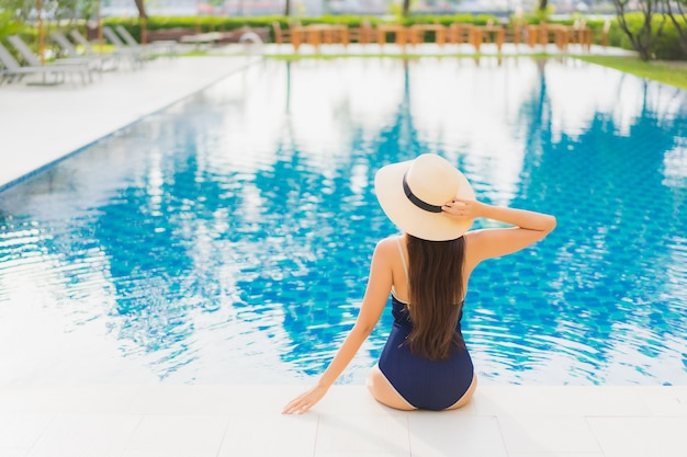 Foto gratuita retrato hermosa joven asiática relajarse sonrisa alrededor de la piscina al aire libre en el hotel resort en viajes de vacaciones