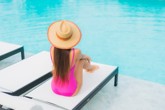 Retrato hermosa joven asiática relajarse sonrisa alrededor de la piscina al aire libre en el hotel resort