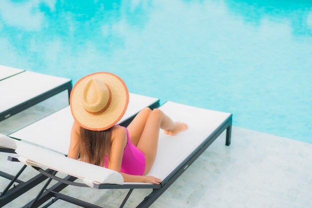 Foto gratuita retrato hermosa joven asiática relajarse sonrisa alrededor de la piscina al aire libre en el hotel resort