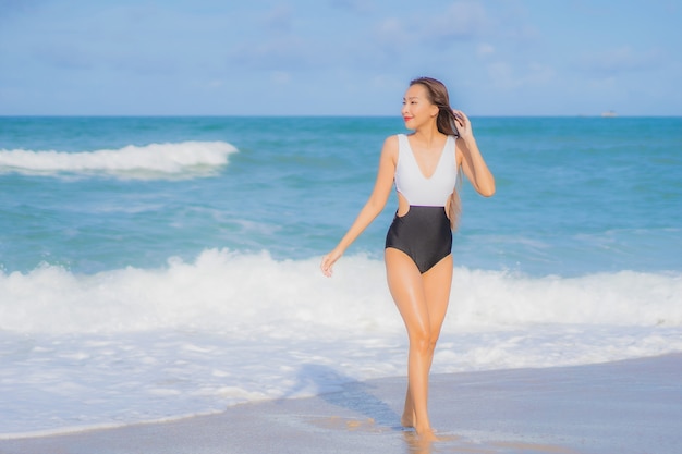 Retrato hermosa joven asiática relajarse sonrisa alrededor de la playa mar océano en vacaciones de vacaciones