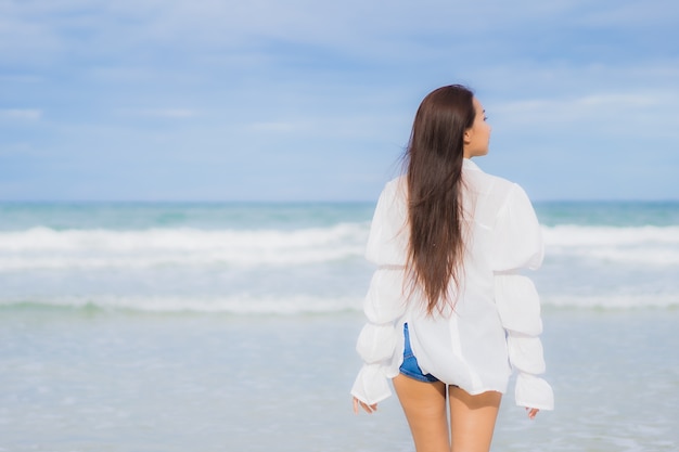 Retrato hermosa joven asiática relajarse sonrisa alrededor de la playa mar océano en viaje de vacaciones vacaciones