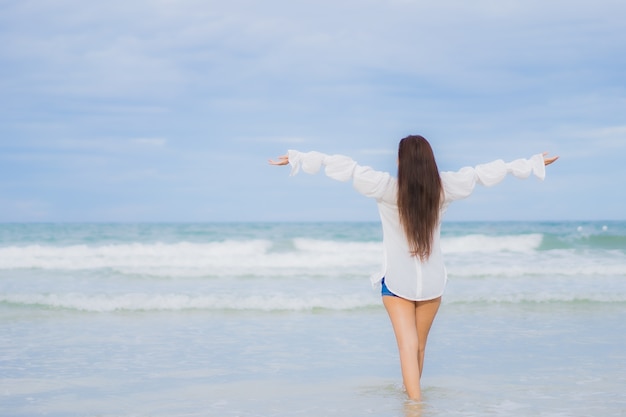 Retrato hermosa joven asiática relajarse sonrisa alrededor de la playa mar océano en viaje de vacaciones vacaciones