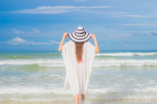 Retrato hermosa joven asiática relajarse sonrisa alrededor de la playa mar océano en viaje de vacaciones vacaciones