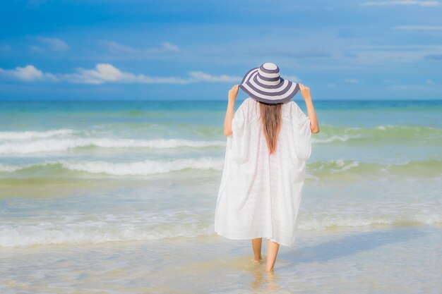 Retrato hermosa joven asiática relajarse sonrisa alrededor de la playa mar océano en viaje de vacaciones vacaciones